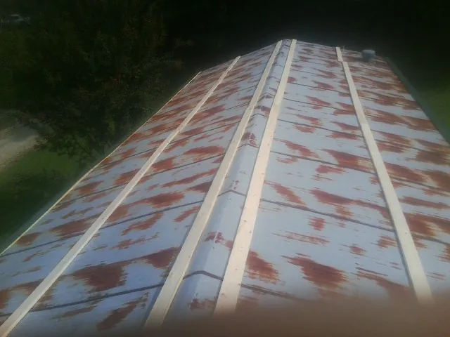 Rusted metal roof panels with new wood purlins before replacement — Storm Damage Roof Repair in Charlo by Roofing Brothers